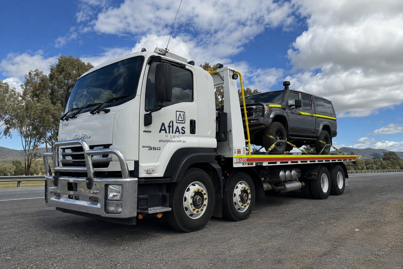 Atlas Hire Isuzu tilt tray carrying a four-wheel drive